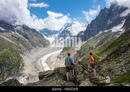 Hikers looking across Mer de Glace glacier from Signal Forbes, Montenvers. Chamonix Valley, French Alps, France. Stock Photo