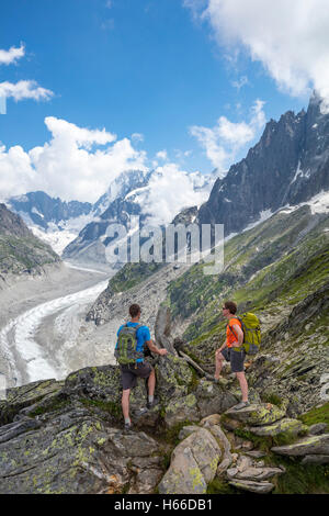 Hikers looking across Mer de Glace glacier from Signal Forbes, Montenvers. Chamonix Valley, French Alps, France. Stock Photo