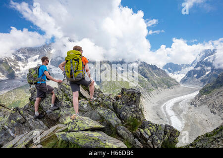 Hikers looking across Mer de Glace glacier from Signal Forbes, Montenvers. Chamonix Valley, French Alps, France. Stock Photo