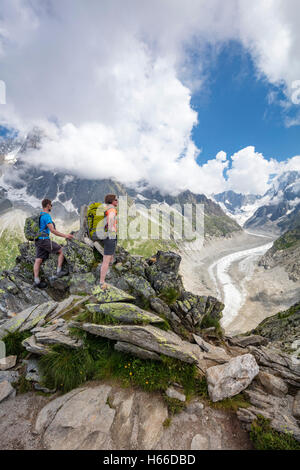 Hikers looking across Mer de Glace glacier from Signal Forbes, Montenvers. Chamonix Valley, French Alps, France. Stock Photo