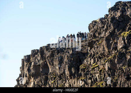 Toursits visting the rift valley in the Pingvellir national Park home of the ancient Icelandic parliement in Iceland, walking through the gorge and taking in the sites. Stock Photo