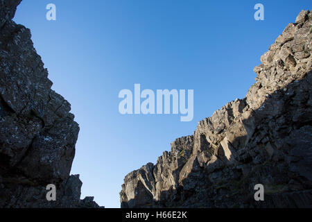 Toursits visting the rift valley in the Pingvellir national Park home of the ancient Icelandic parliement in Iceland, walking through the gorge and taking in the sites. Stock Photo