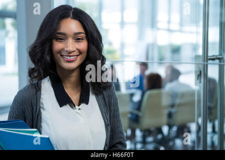 Portrait of beautiful businesswoman holding files Stock Photo