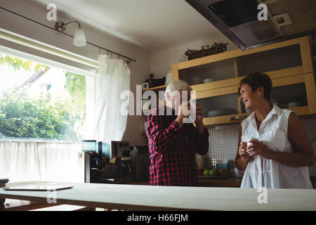 Senior couple interacting while having coffee Stock Photo
