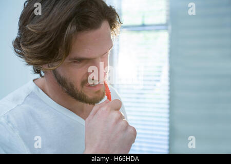 Man brushing his teeth in bathroom Stock Photo