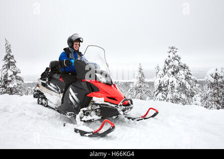 Man driving snowmobile in Finland Stock Photo