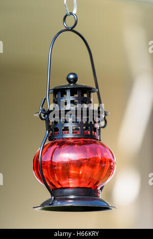 Oil lamp wick lantern made of red glass and metal isolated on