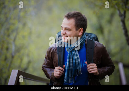 Close up portrait of a happy young man traveling with backpack. Stock Photo