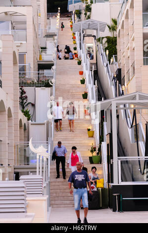 People walking up and down a tall set of outdoor steps at a hotel Stock Photo