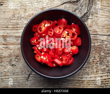 Bowl of red hot chili pepper on wooden table, top view Stock Photo