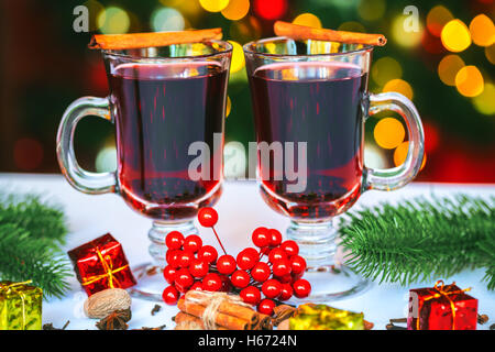 Beautiful two glasses of mulled wine standing on the background of a blurred decorated Christmas tree. Soft focus. Shallow DOF Stock Photo