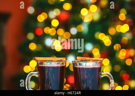 Beautiful Two glasses of mulled wine on bokeh background decorated Christmas tree. The idea for postcards. Soft focus. Shallow D Stock Photo