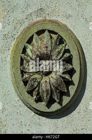 Old door carved detail with a flower in the centre of the frame. Stock Photo
