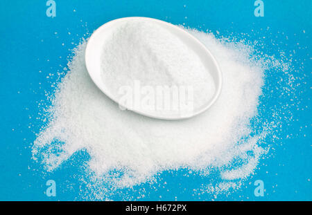 White sugar in bowl isolated on blue Stock Photo