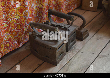 Ancient irons on a timber floor. Reconstruction of life of Cossacks of Kuban. Stock Photo