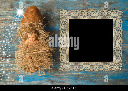 Christmas time vintage photo frame, antique Baby Jesus on primitive wooden background Stock Photo