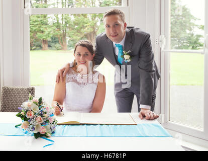 Newly weds signing the register after their wedding ceremony Stock Photo