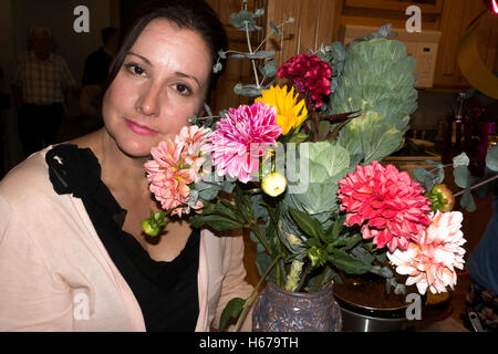 Thoughtful woman posing by a beautiful bouquet of azalea flowers. Champlin Minnesota MN USA Stock Photo