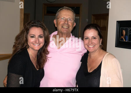 Happy portrait at dad's 75th birthday party with his two loving daughters. Champlin Minnesota MN USA Stock Photo