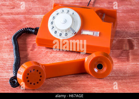 Old orange retro phone with rotary dial Stock Photo