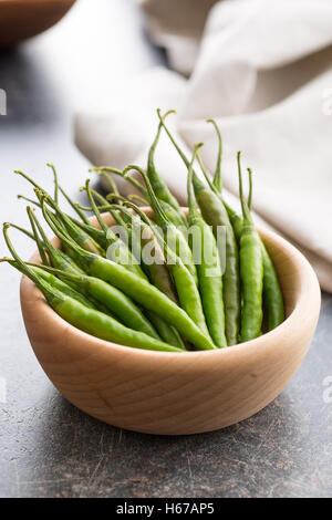 Green chili peppers in wooden bowl. Stock Photo