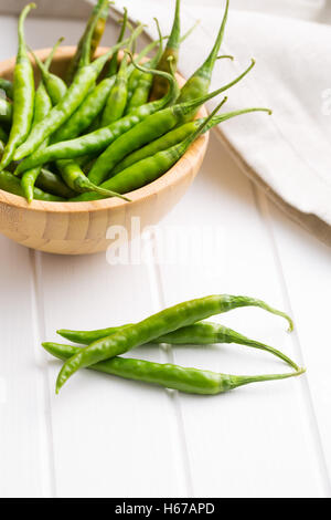 Green chili peppers on white table. Stock Photo