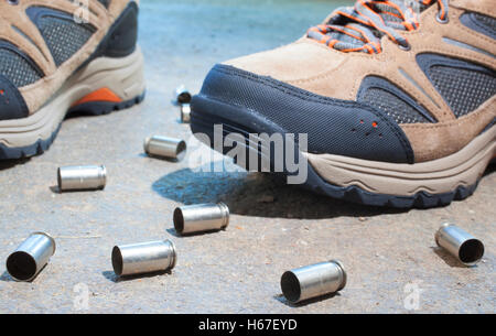 Pair of tennis shoes on concrete with empty shells around Stock Photo