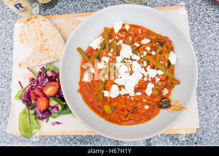 Café lunch Fasolakia or Greek Bean Stew served with Feta cheese salad and warm Pitta Bread Stock Photo