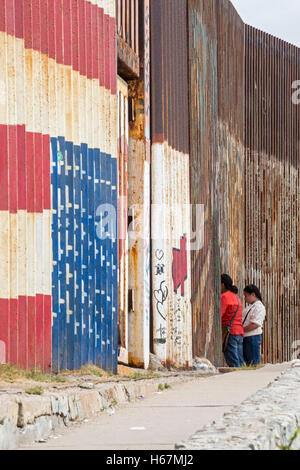 Tijuana, Mexico - Family members separated by deportation visit through the U.S.-Mexico border fence. Stock Photo