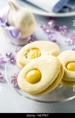 Homemade easter cookies and funny easter bunny on blue pastel background. Easter table setting Stock Photo