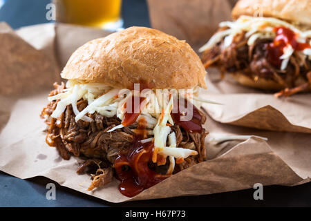 Pulled pork sandwich with cabbage slaw on top served on paper Stock Photo