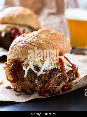 Pulled pork sandwich with cabbage slaw on top served on paper Stock Photo