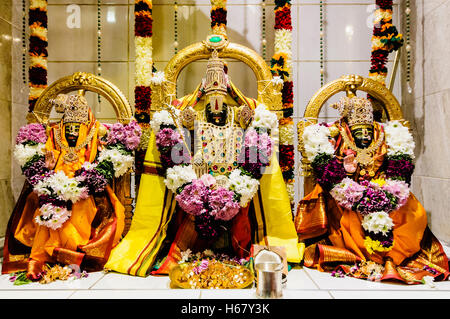 Ornate Hindu Deities and gifts at the altar of a Temple. Stock Photo
