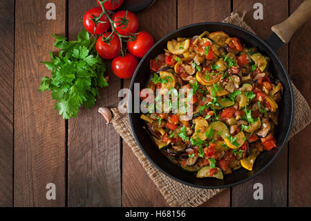 Vegetable Ratatouille in frying pan on a wooden table. Top view Stock Photo