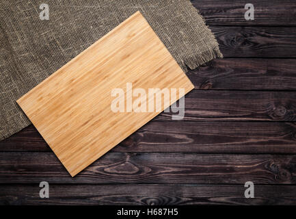 Cutting board on dark old wooden table. Top view Stock Photo