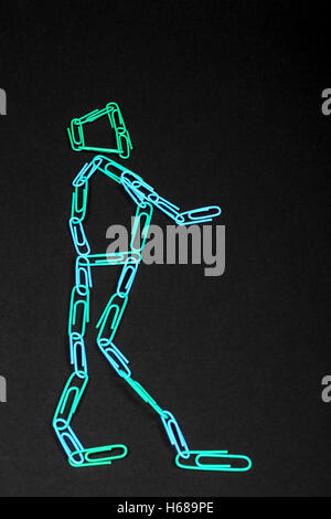Paper clip man shape (outline) isolated on a black background Stock Photo