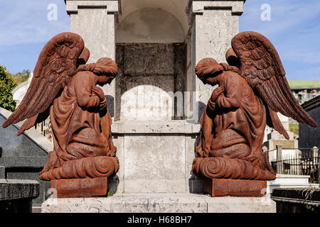 Sculpture of two angels praying at a grave in the cemetery of the town of Laredo, Cantabria, Spain, Europe. Stock Photo