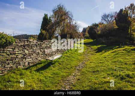 A bench next to a hiking path on a meadow in Monschau, Germany. Stock Photo