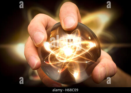 Holding atom in fortune teller magic crystal ball Stock Photo