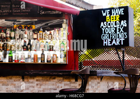 Sign outside a cocktail bar saying 'We have beer as cold as your ex girlfriend's heart' Stock Photo