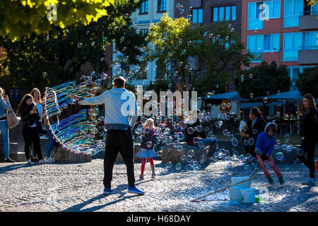 Germany, Cologne, man makes soap bubbles at the Rhine garden in the old part of the town. Stock Photo