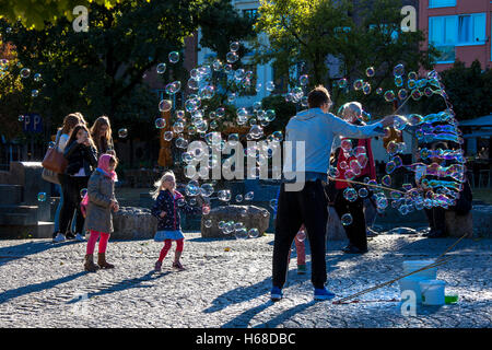 Germany, Cologne, man makes soap bubbles at the Rhine garden in the old part of the town. Stock Photo