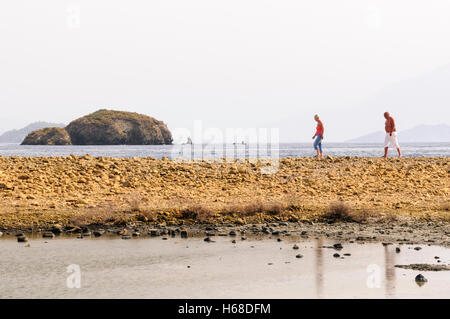 a-tourist-couple-walk-along-the-rocks-during-sunset-in-the-ayia-napa
