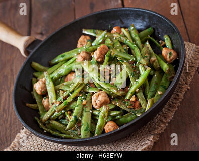 Green beans fried with chicken meatballs and garlic Asian style. Stock Photo