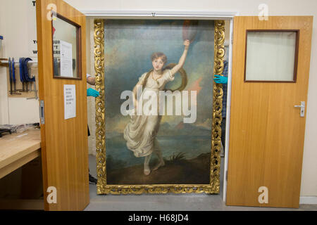 Conservators carry a newly reframed portrait of Horatia Nelson, the daughter of Emma Hamilton and naval hero Horatio Nelson, at the National Maritime Museum in London. Stock Photo