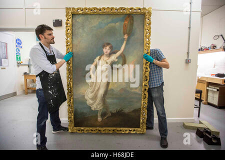 Conservators carry a newly reframed portrait of Horatia Nelson, the daughter of Emma Hamilton and naval hero Horatio Nelson, at the National Maritime Museum in London. Stock Photo