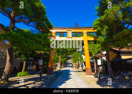 Large wooden torii gate entrance to Sakurayama Hachiman-gu Shinto Shrine on a clear blue sky day in Takayama, Japan Stock Photo