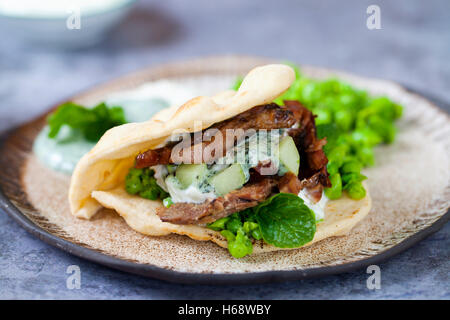 Mini flat breads with crispy lamb, mashed peas, cucumber, mint and yogurt sauce Stock Photo