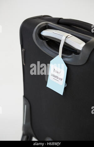 Travel insurance label tied to a suitcase Stock Photo
