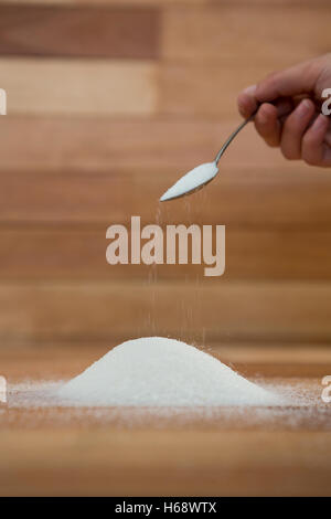 Woman hand pouring sugar from spoon Stock Photo